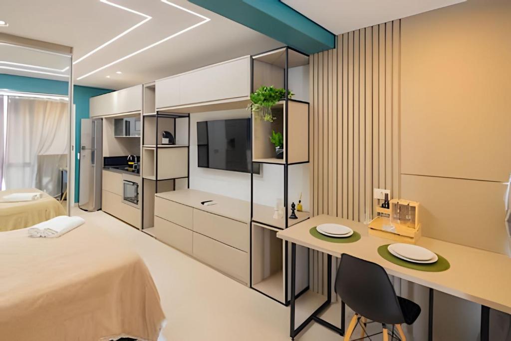 a bedroom with a bed and a desk with two chairs at 1904 Lindo studio super moderno in Guarulhos