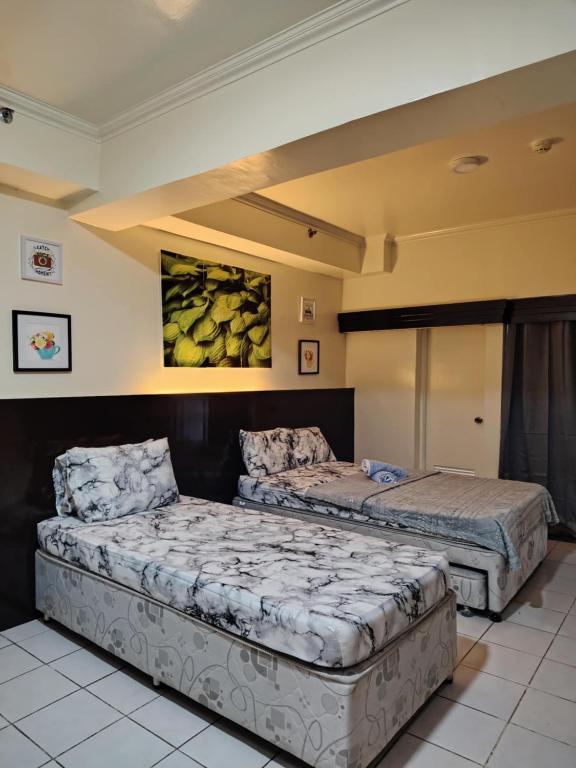 two beds sitting in a room with at Jhohanna's Cozy Corners in Iruhin
