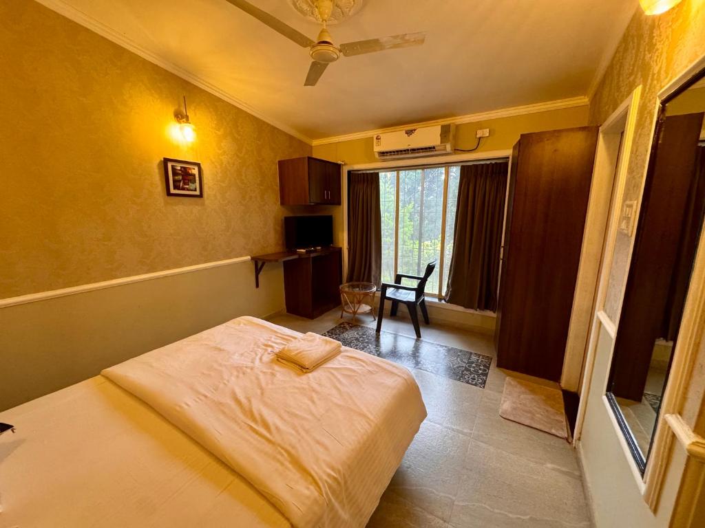 a small bedroom with a bed and a window at Aurum Meadows in Panchgani