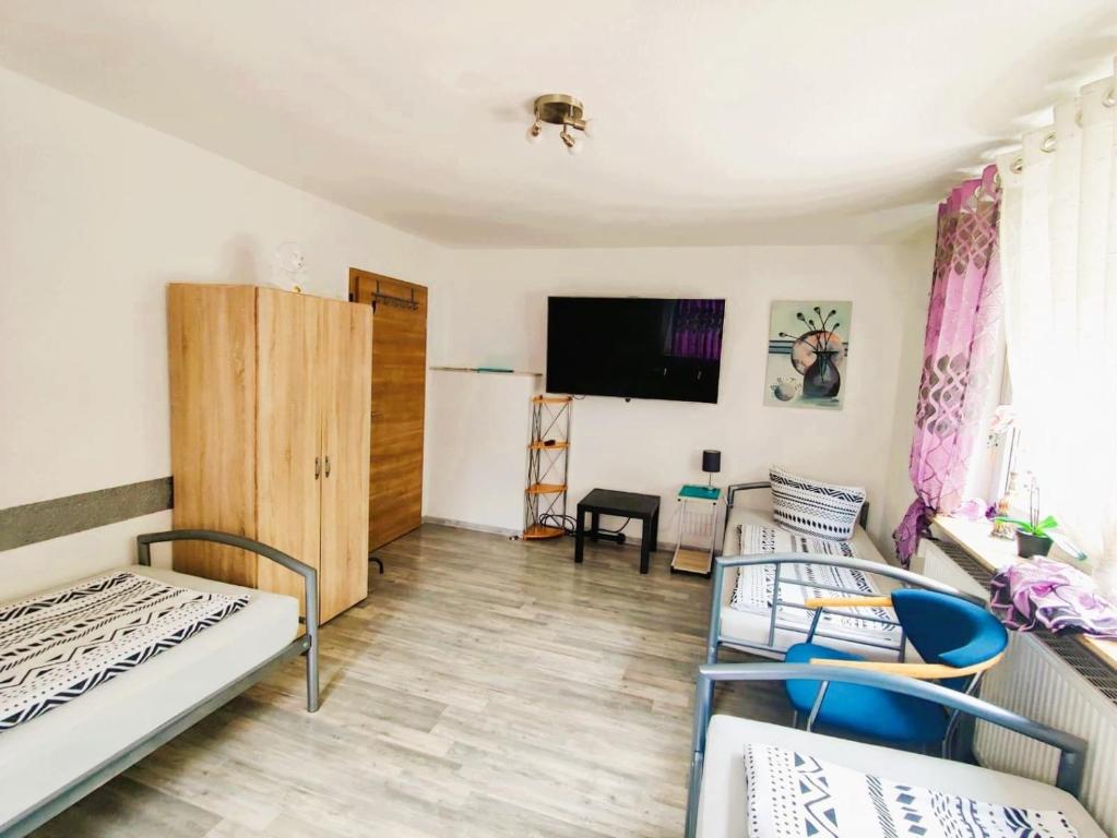 a room with two beds and a tv on the wall at Ferienwohnung Bailey in Laupheim