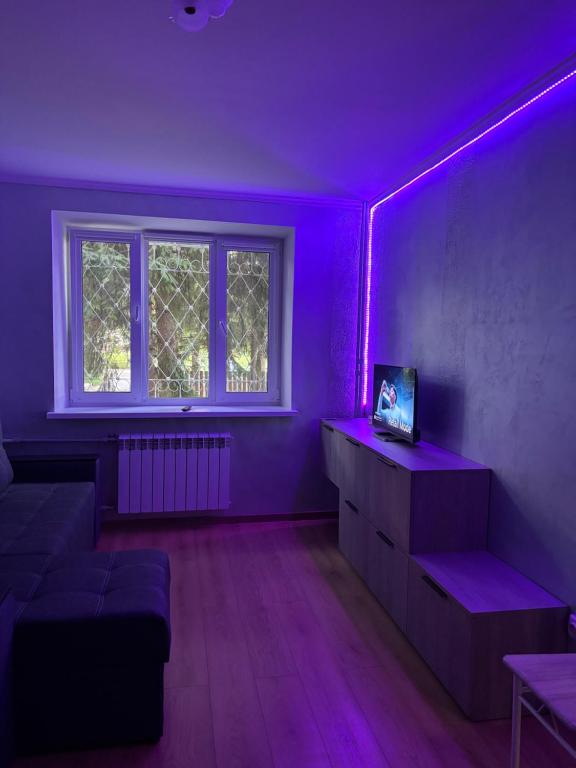a purple room with a couch and a window at MILANIA однокомнатная квартира in Poltava