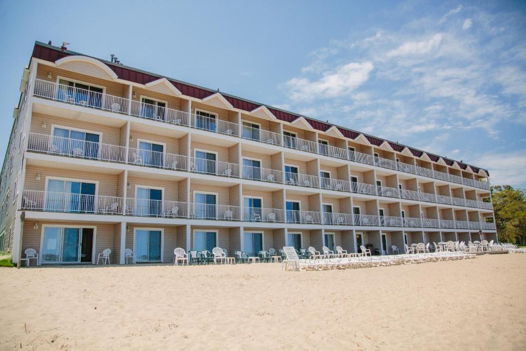 un hotel sulla spiaggia con sedie e tavoli di Bayshore Resort a Traverse City