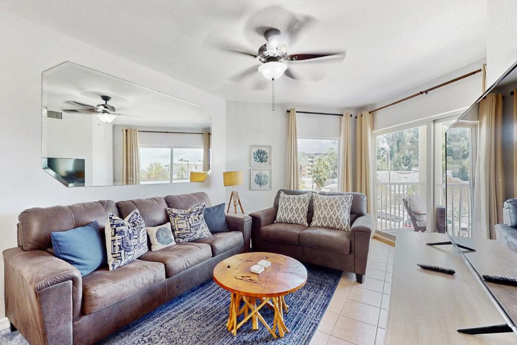 een woonkamer met een bank en een tafel bij Sunset Vistas Condo 203S in St Pete Beach