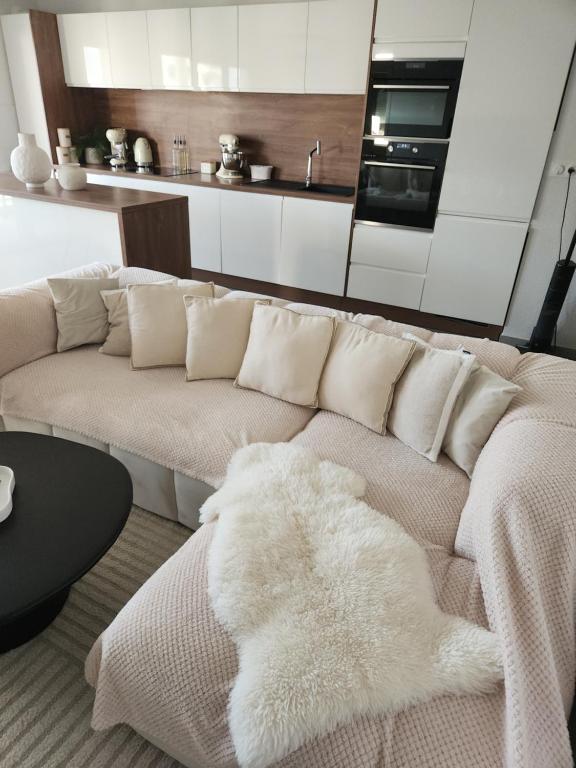 a living room with a couch with a white blanket at Appartement neuf in Ajaccio