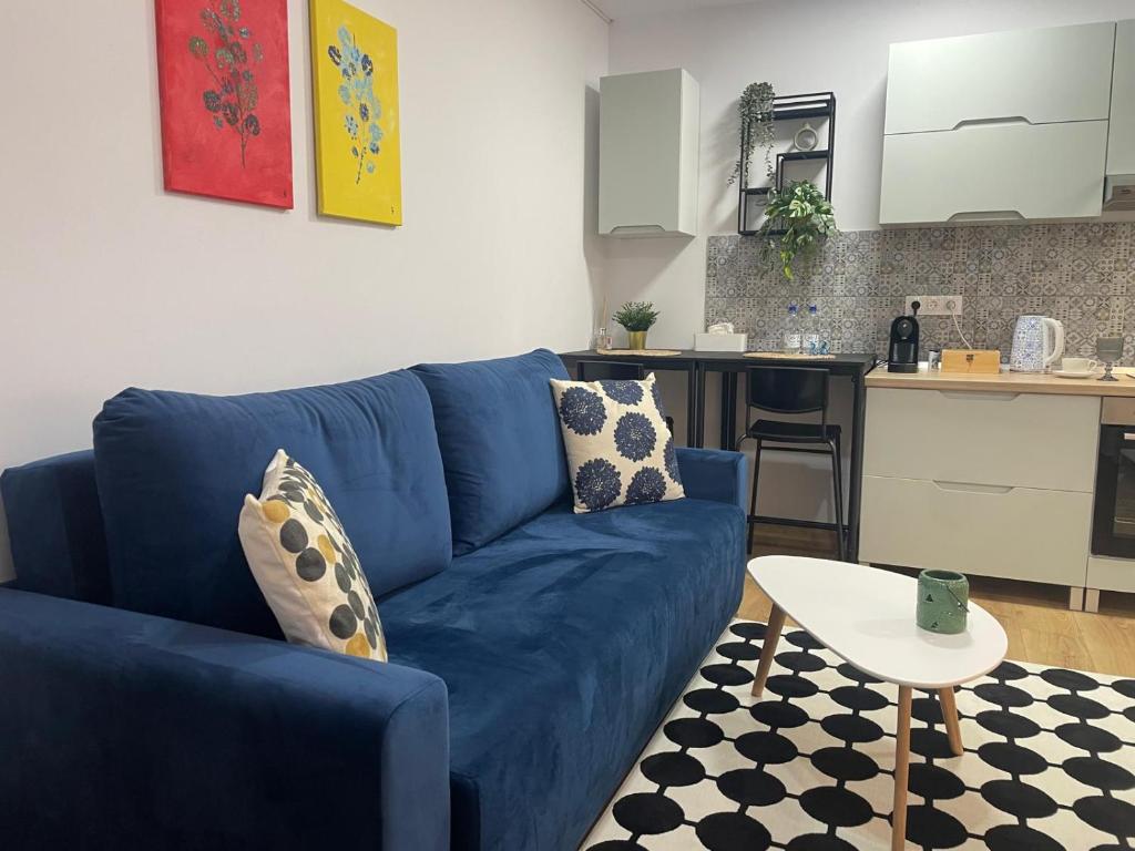 ein blaues Sofa im Wohnzimmer mit Küche in der Unterkunft Apartament Corvin 2 in Hunedoara