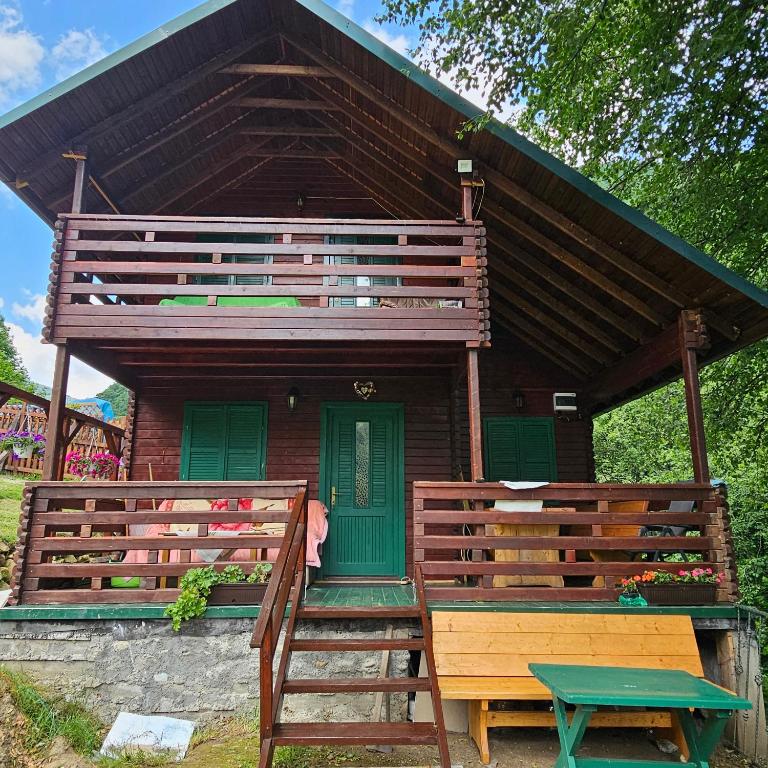 a small house with a porch and a green door at Magic Cottage From Paradise in Râu de Mori