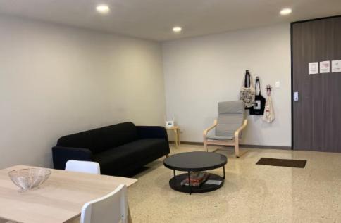 a living room with a black couch and a table at Habitación Shefa Solar 3 in Puebla