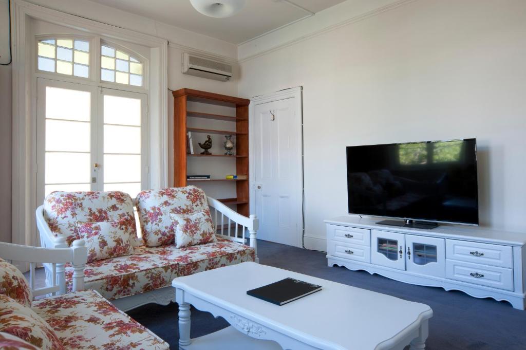 sala de estar con sofá y TV en Lowena Cafe and Accommodation, en Hobart