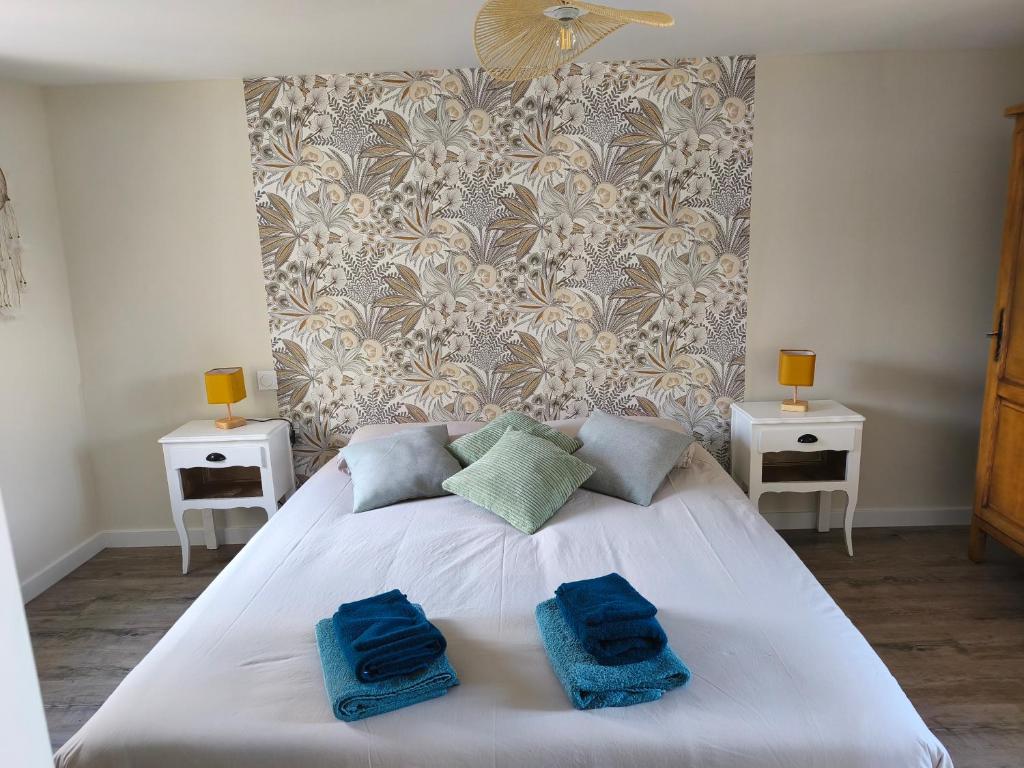 a bedroom with a white bed with two blue towels on it at Gite de la perle rouge 1 Chambre 2-4 personnes in Rodelinghem