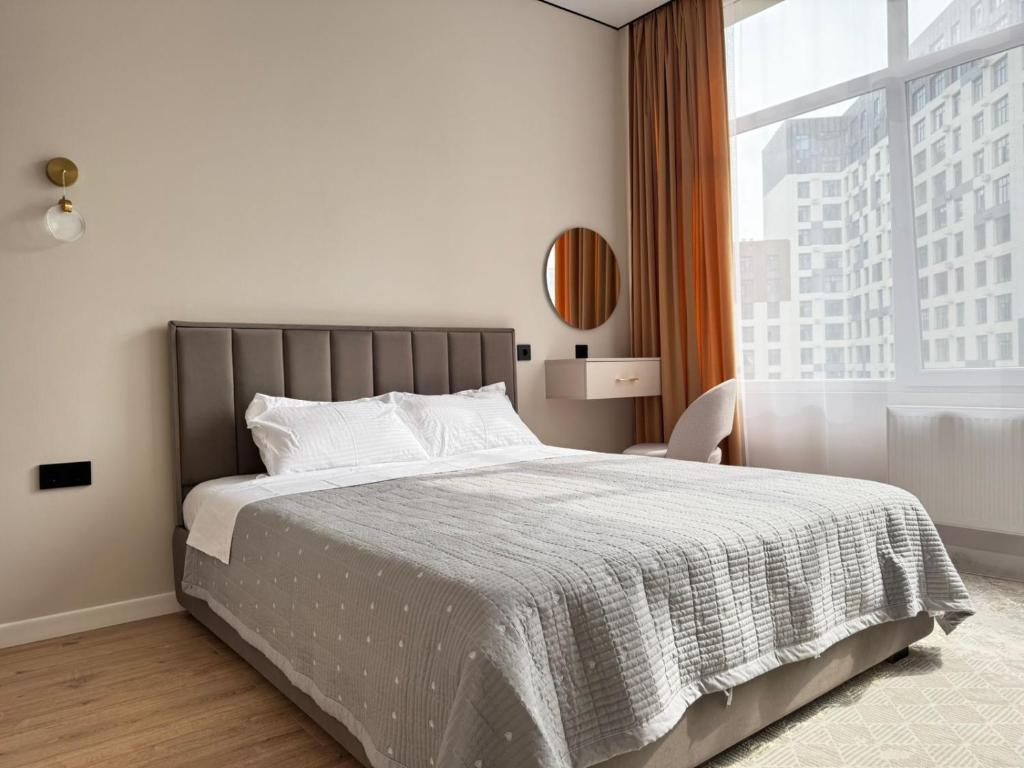 TaldykolʼにあるАпартаменты, в которые хочется возвращатьсяのベッドと大きな窓のある寝室