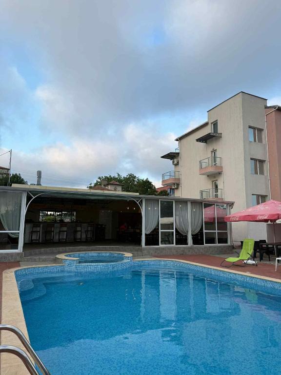 a large swimming pool in front of a building at Къща за гости ГАЛАНТ in Byala