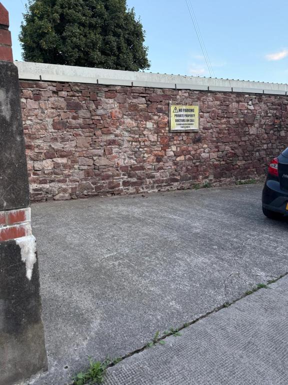 a brick wall with a car parked in a parking lot at Stylish Industrial 1 Bed in Bristol