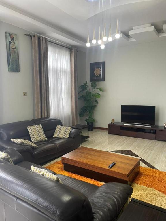 a living room with a leather couch and a coffee table at BiG LUXURY VILLA in Dar es Salaam