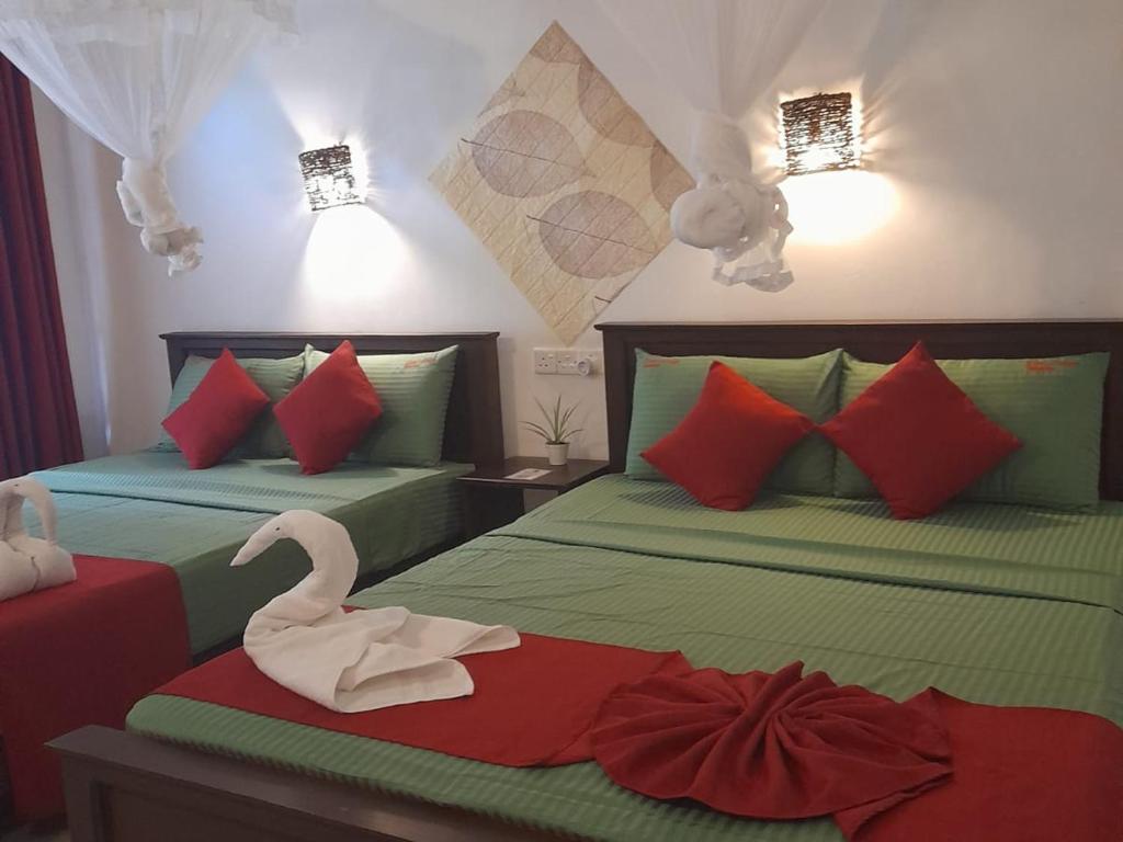 a bedroom with two beds with a swan on them at The Cozy Cottage Habarana in Habarana