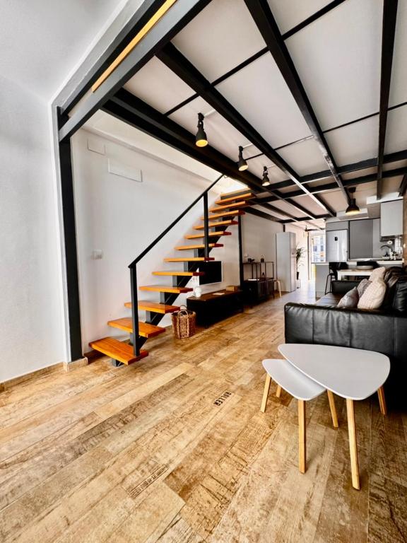 a living room with a couch and a staircase at Brisas a un paso del centro in Valencina de la Concepción