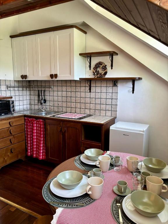 a kitchen with a table with plates and cups on it at Casa Costanza in Pescasseroli