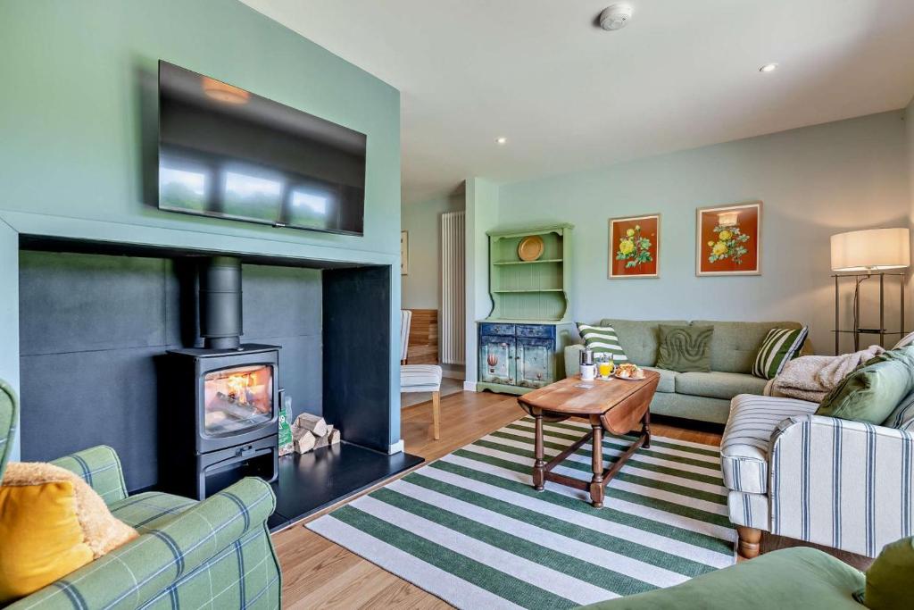 a living room with two couches and a fireplace at Ash View 2 in Corsley