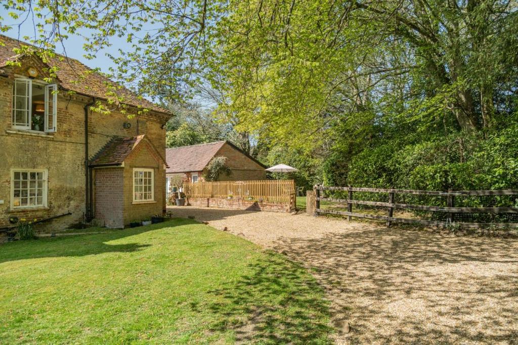une vieille maison en briques avec une clôture et une cour dans l'établissement Landfords Cottage, à Landford