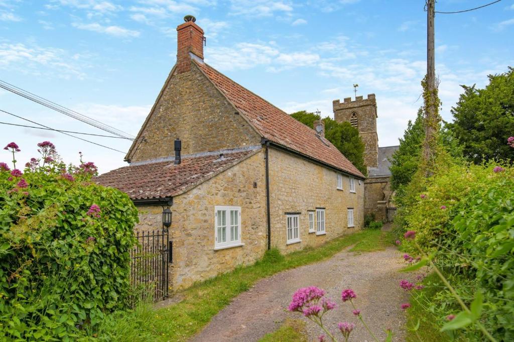 ein altes Steinhaus mit einem Turm in der Unterkunft Rose Cottage - Powerstock in Powerstock