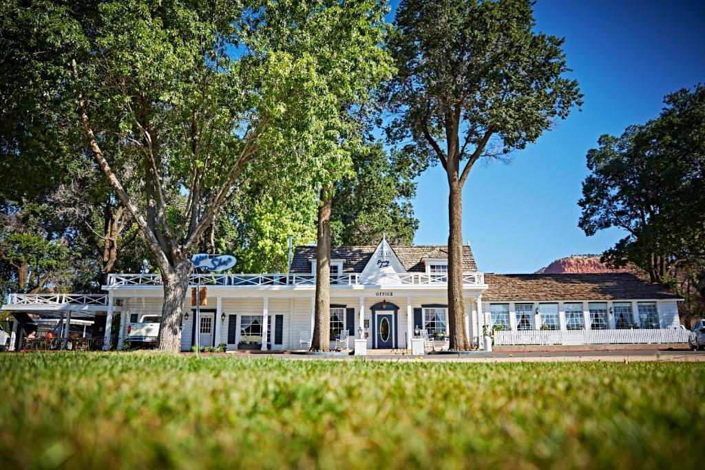 a white house with trees in front of it at Parry Lodge in Kanab