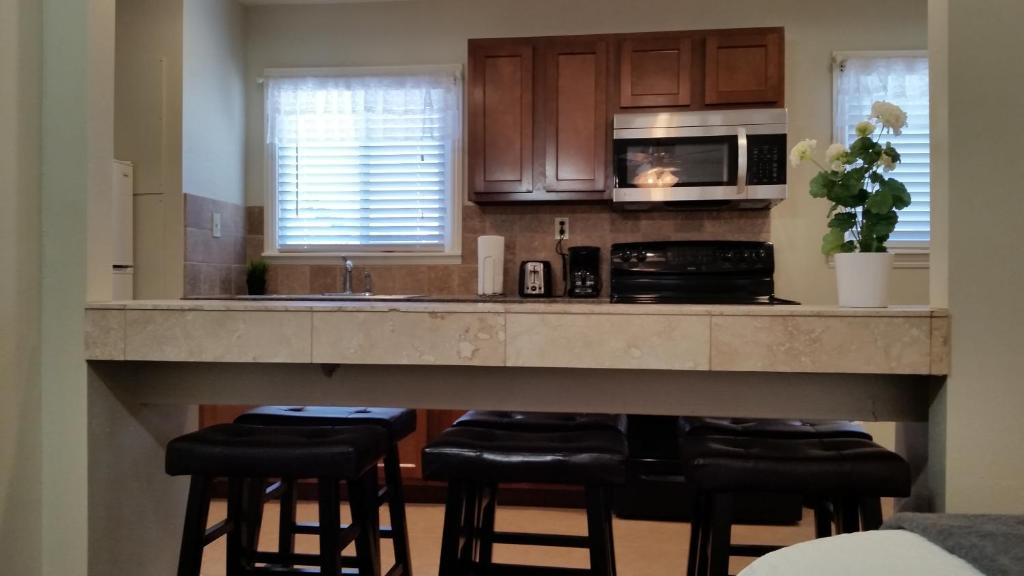 a kitchen with a counter with stools and a microwave at Trees Motel in Bishop