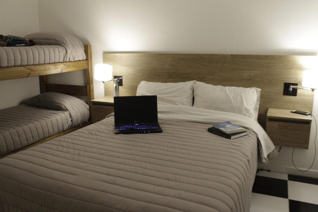 a laptop computer sitting on a bed in a hotel room at Hotel Low Cost Bahía in Bahía Blanca