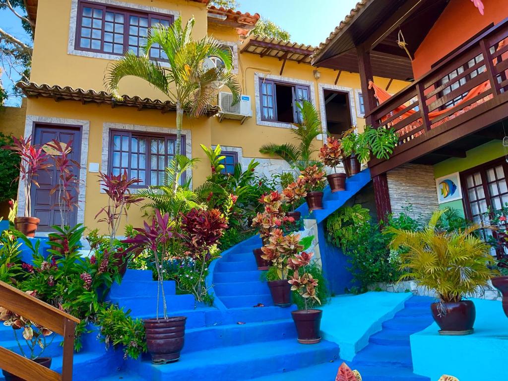 ein Haus mit blauen Treppen und Topfpflanzen in der Unterkunft Flats Tartaruga Búzios in Búzios
