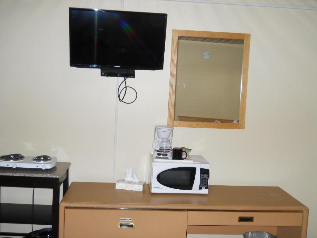 um micro-ondas sentado em cima de uma mesa com uma televisão em TC Motel em Medicine Hat