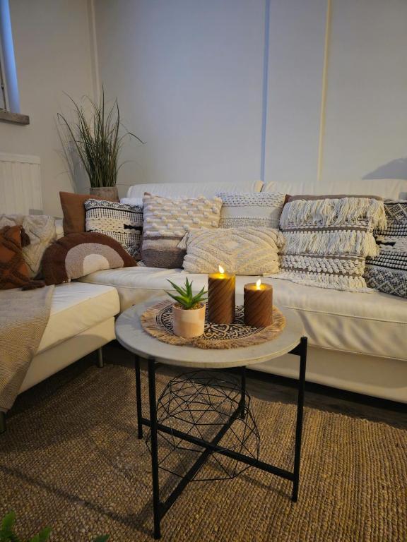 a living room with a couch and two candles on a table at 3room apartment at central Jyväskylä in Jyväskylä