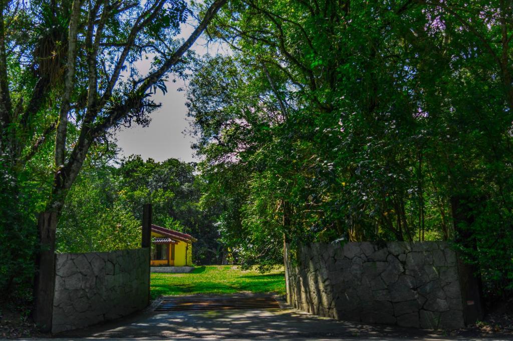 een pad met bomen en een stenen muur bij Pousada Chalé Amoreira in Visconde De Maua