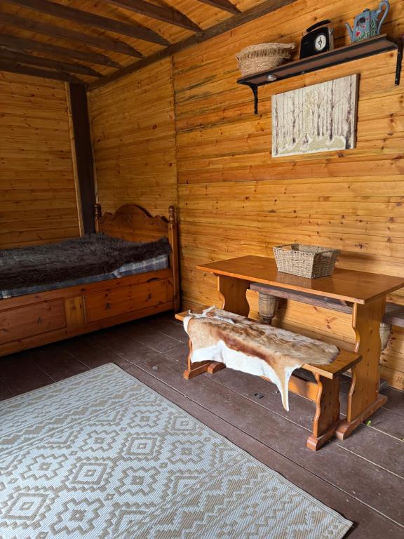 a wooden cabin with a table and a bed at Willow Lodge in Llancarfan