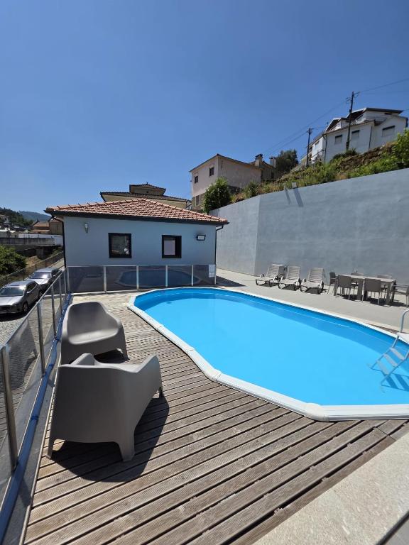 a swimming pool on top of a wooden deck at Douro Valley - Casa do Padrinho in Escamarão