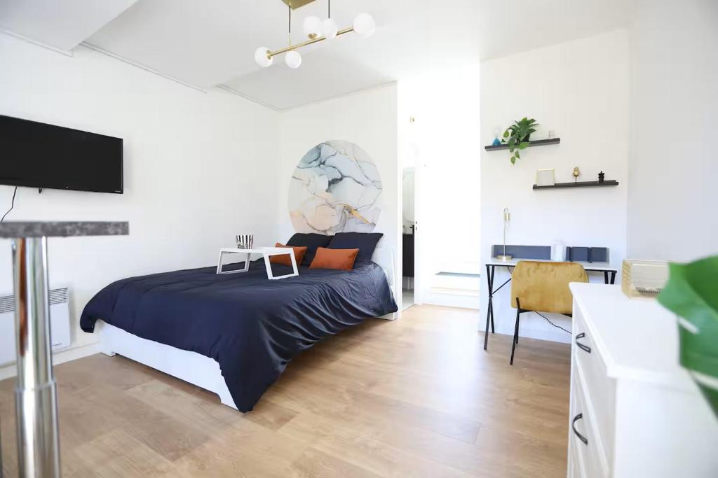 a bedroom with a bed and a desk in it at Studio calme avec extérieur et entrée autonome in Saint-Sébastien-sur-Loire