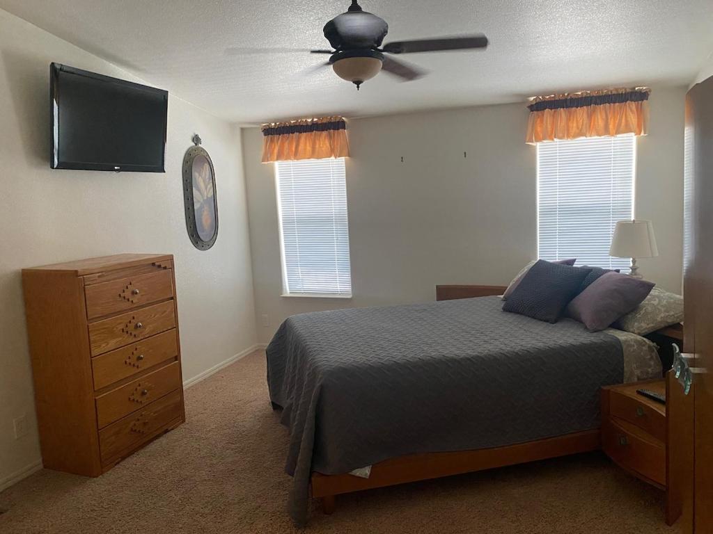 een slaapkamer met een bed en een plafondventilator bij Parker Pair - Sunset Escape in Parker