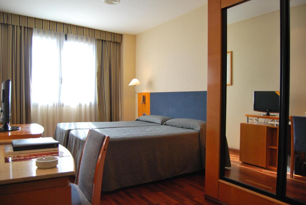 a hotel room with a bed and a television at Hotel Villacarlos in Valencia