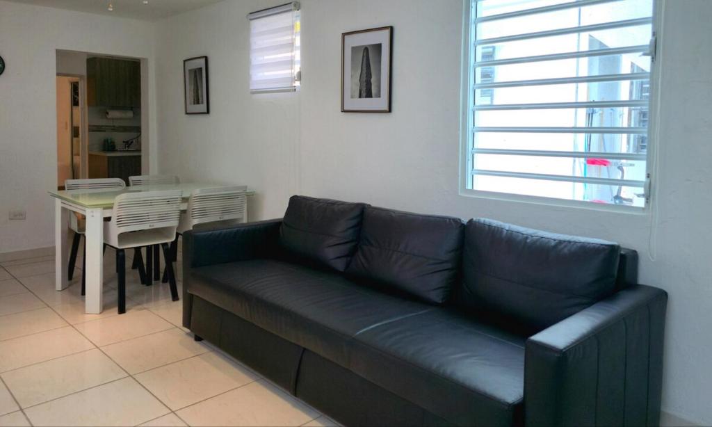 ein Wohnzimmer mit einem blauen Sofa und einem Tisch in der Unterkunft Oscar Building - Apto#1 in San Juan