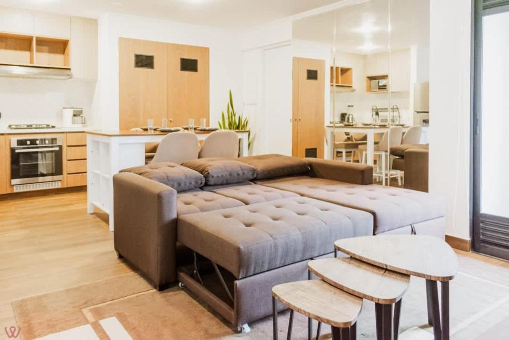 a living room with a couch and a kitchen at Magnificent 2BR Pool in Miraflores in Lima