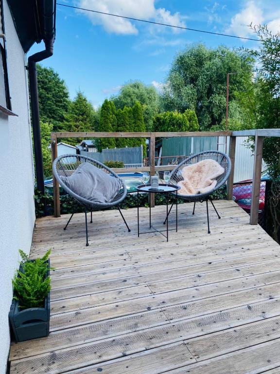 two chairs and a table on a wooden deck at Apartament 88 - Mrągowo Centrum, 2 sypialnie, taras in Mrągowo