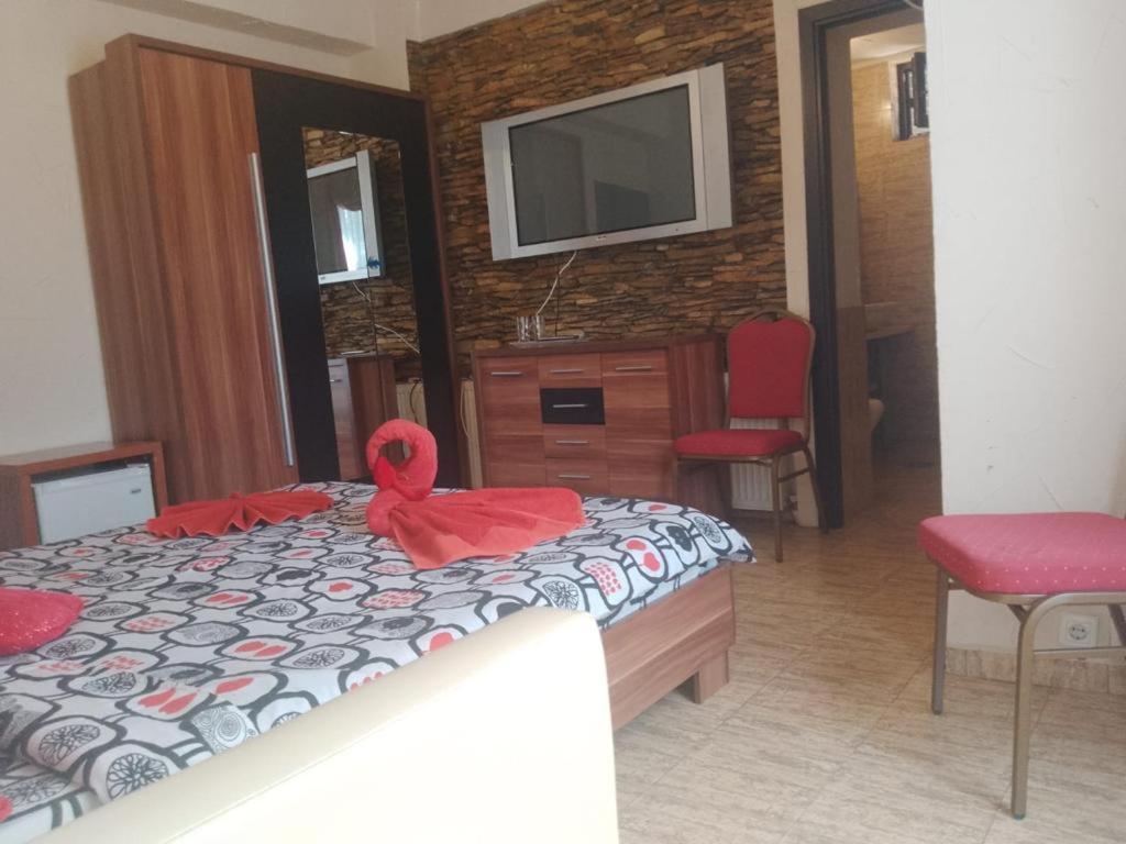 a bedroom with a bed with a red bow on it at Samaya in Eforie Nord