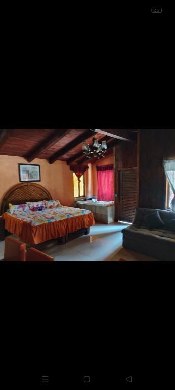 a large bedroom with a bed and a couch at Cabañas Ángela in Mazamitla