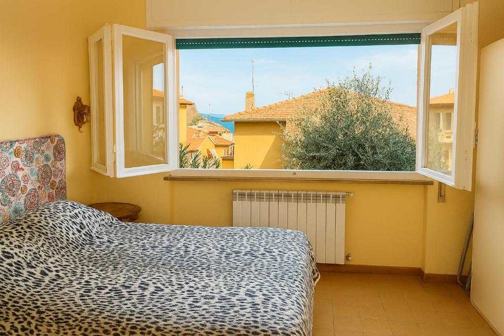 Un dormitorio con una cama y una ventana grande. en Casa della Costa - Porto Ercole Mare-, en Porto Ercole