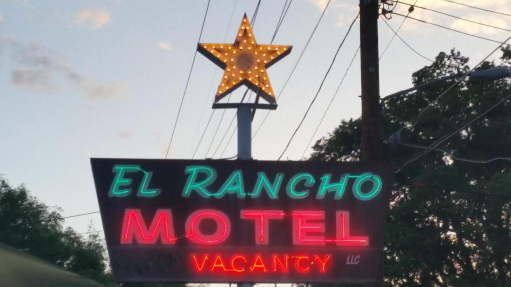 un cartel de neón para un motel con una estrella en la parte superior en El Rancho Motel, en Bishop