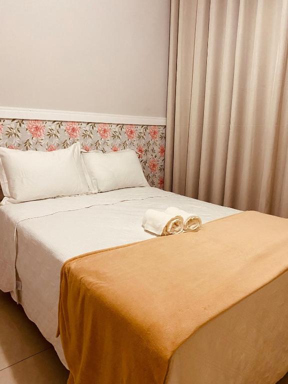 a bed with two gold wedding rings on it at Apto Suite Aconchegante a 03 minutos do Bairro Horto in Coronel Fabriciano
