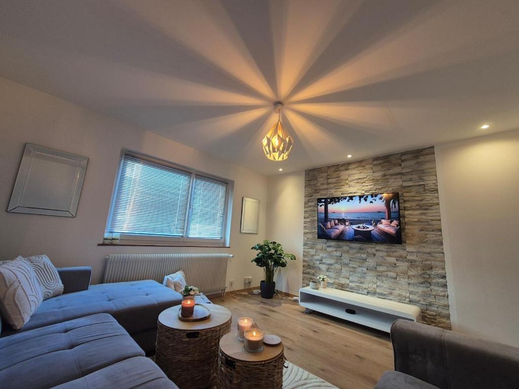 a living room with a blue couch and a tv at Escapade saint louis Basel in Saint-Louis