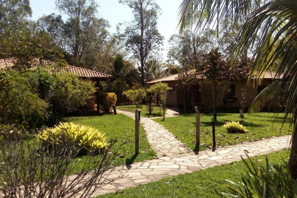 a garden with a path leading to a house at Recanto das Águas in Britânia