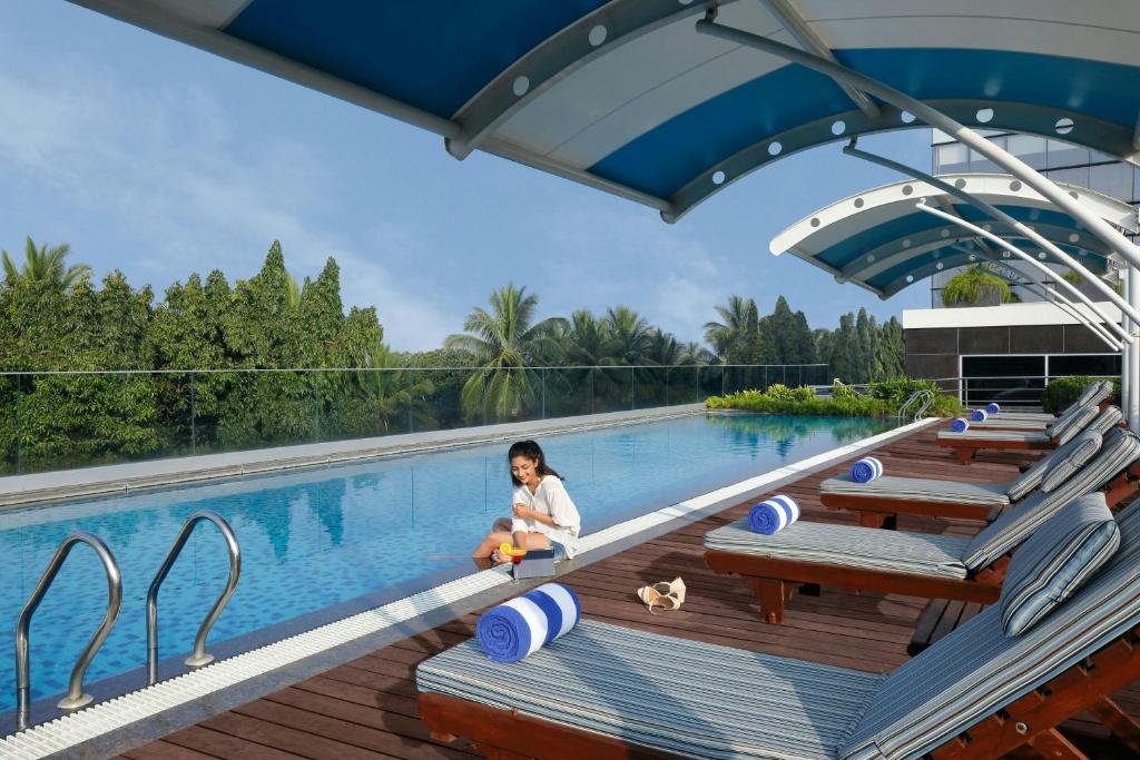 a little girl sitting next to a swimming pool at Fairfield by Marriott Belagavi in Belgaum