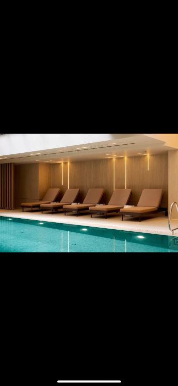 a row of chairs sitting next to a swimming pool at Emmanuel suits in Eilat