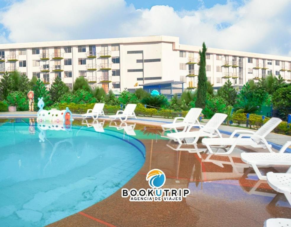 a swimming pool with chairs and a building at Aparthotel 2km Parque del Café BOOKUTRIP - 311-227-59-73 in Montenegro