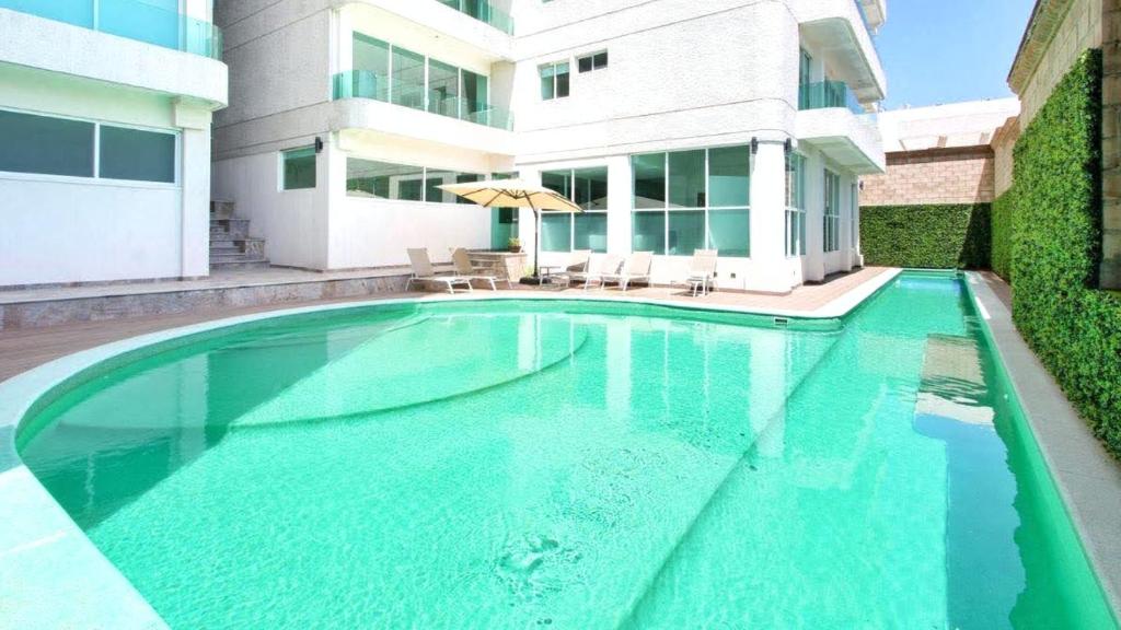 ein Schwimmbad vor einem Gebäude in der Unterkunft Puebla Vista Malinche in Lomas de Angelopolis