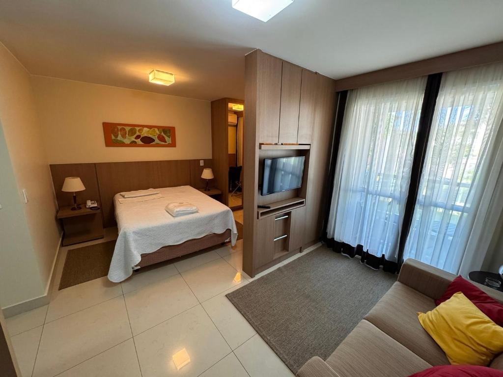 a hotel room with a bed and a television at The Sun - Flat in Brasilia
